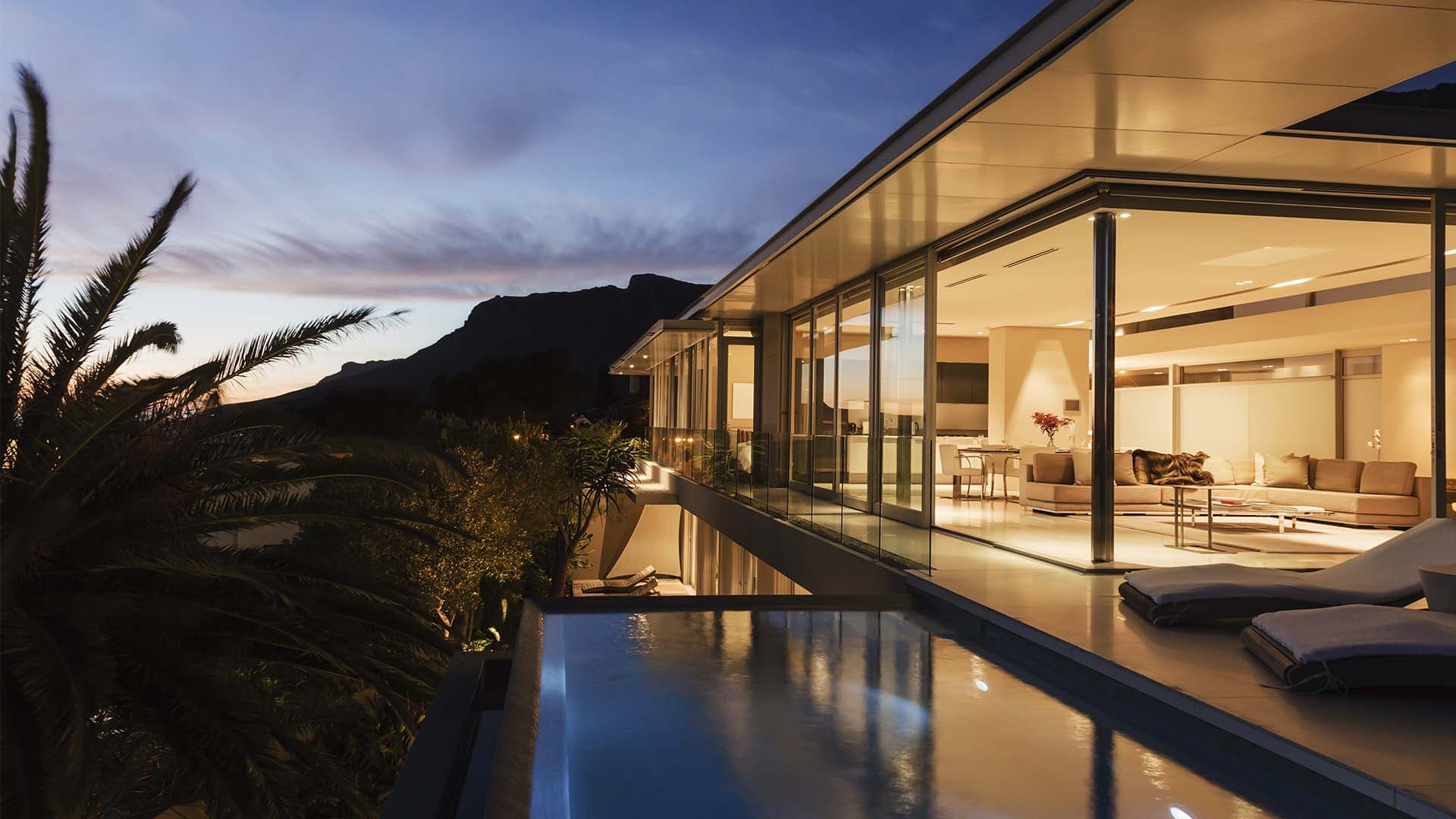 Empreendimento de alto padrão com por do sol e vista ampla da lateral da casa com portas de alumínio e vidro.